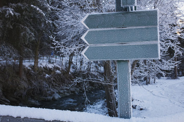 Fototapeta premium Three arrow signs pointing to the left in a winter landscape.