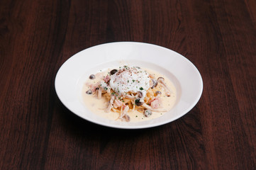 Italian pasta spaghetti with creamy alfredo sauce, mushroom and poached egg