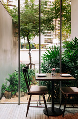 Dinner table in modern restaurant with tropical garden view