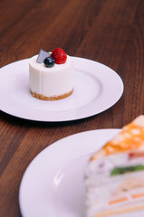 Creamy cheesecake with raspberry and blueberry on white dish in bekery cafe