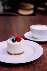 Creamy cheesecake with raspberry and blueberry on white dish in bekery cafe