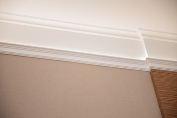 Interior details ceiling stucco plaster. Decorating wall joint using lighting © Parilov