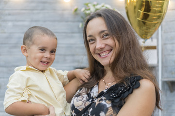 Mom holds a child in her arms. A happy family. Young mother holding her baby in her arms and stroked my mother's child litso.Portret mother and little son