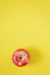 Red fresh apple on a yellow background. Close-up, copy space