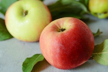 Fresh apple fruits close up, juicy red apples with green leaves