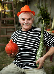 Man with hat holding pumpkins