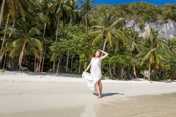 Happy traveller woman in white dress enjoys her tropical beach vacation on El Nido, Palawan, Philippines