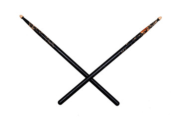 two crossed used black drumsticks on white background