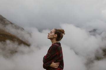 Woman above the clouds in the mountains - 226836875