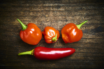 Group of Red fresh chilli on old rustic wood desk. Food background. Cooking. Selective focus
