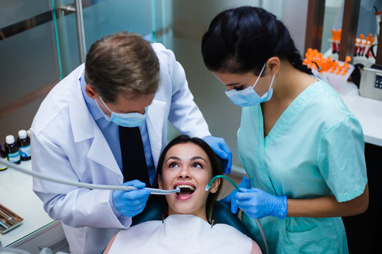 Not Scary At All! Top View Of Dentist With His Assistant Examining His Patient In Dentist’s Office