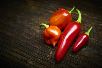 Group of Red fresh chilli on old rustic wood desk. Food background. Cooking. Selective focus