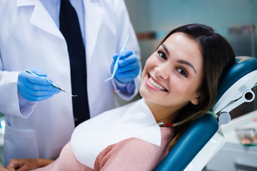 Her amazing smile! Beautiful young woman looking at camera with smile in dentist’s office - obrazy, fototapety, plakaty