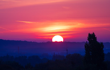 Amazing sunrise or sunset in rural scene. Close up on sunbeamnover the horizon.