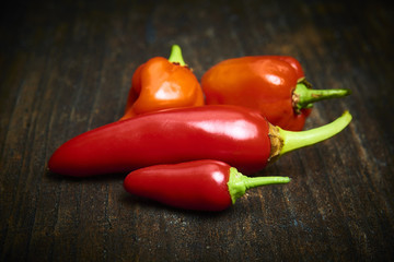 Group of Red fresh chilli on old rustic wood desk. Food background. Cooking. Selective focus