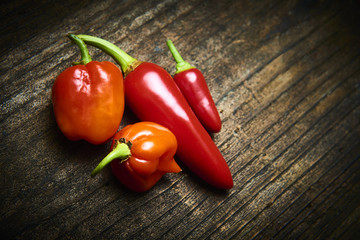 Group of Red fresh chilli on old rustic wood desk. Food background. Cooking. Selective focus