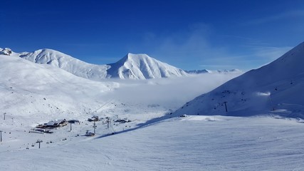 Obraz premium Image of ski resort in the mountains with low stratus over the valleys