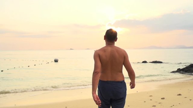 Young man walking on beach
