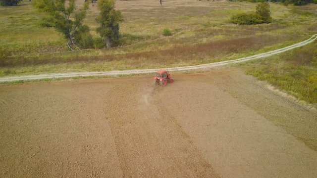 aerial view of an old tractor plowing on an agricultural field