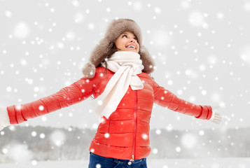 people, season and leisure concept - happy woman in winter fur hat outdoors