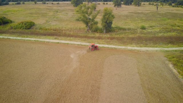 aerial view of an old tractor plowing on an agricultural field