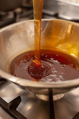 fliessende Honig in Schale auf Herd