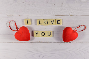 Red hearts and "I Love You" text on white wooden background