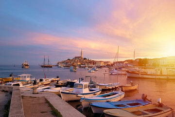 Rovinj, old costal town of Croatia in golden sunrise light. Motorboats, boats and yachts on water...