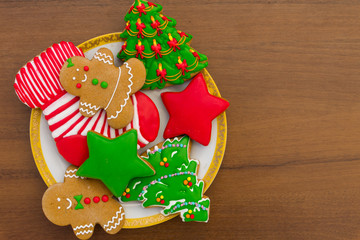 Plate with tasty Christmas cookies on wooden table