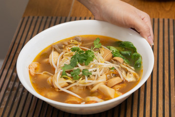 a female hand hold a bowl of vietnamese pho noodle soup