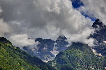 Peak of the mountain with glaciers against the background of clouds and sky. Caucasian ridge,...