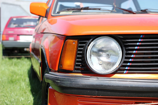 Exhibition of a retro cars. Big round headlight of a sports coupe bmw m3 e21.
