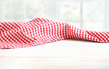 Red picnic cloth on wooden background.