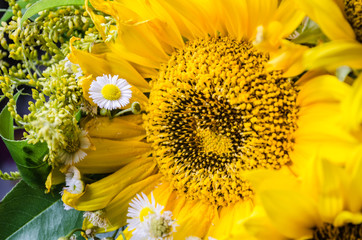 Mulltilobe yellow sunflower with small white daisy in a bouquet.
