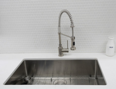Modern kitchen stainless sink and faucet with tile and quartz