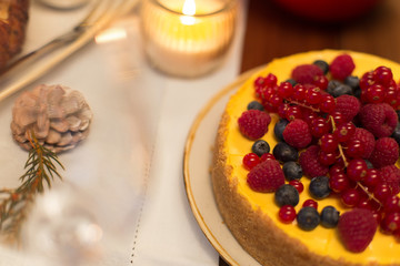 christmas dinner and eating concept - close up of berry cake on table