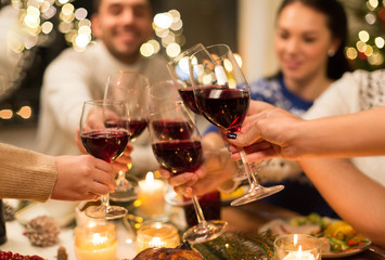 holidays and celebration concept - close up of happy friends having christmas dinner at home,...