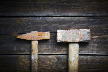 Close up of two old used hammer on a rustic wooden background. Selective focus