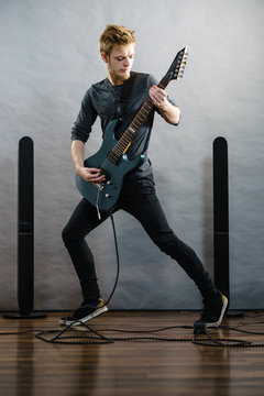 Young man playing electric guitar