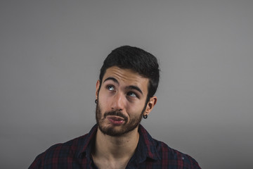 young attractive man with beard thinking, young man looking up