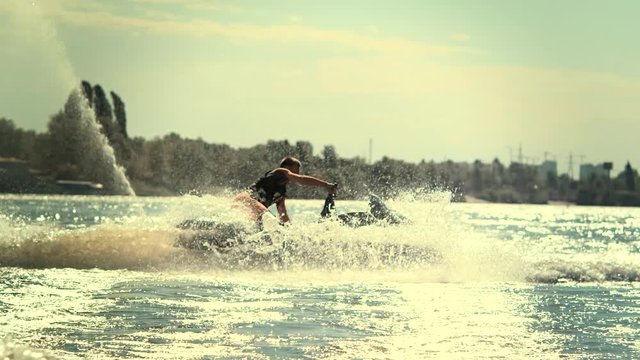 Sportsman swirling on speedy jet ski at sunset in slow motion. Extreme water sport. Jet ski rider enjoy water waves