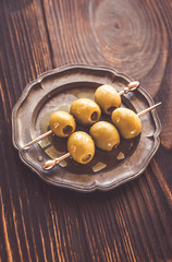 Olive skewer on the vintage plate
