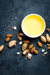 Fototapeta na wymiar Almond oil in bowl and almond nuts. Almonds