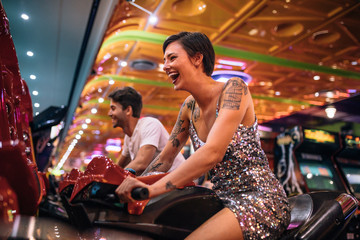 Fototapeta na wymiar Happy couple having fun playing arcade racing games
