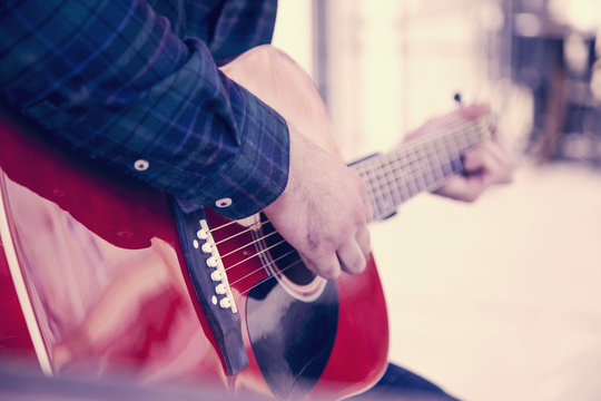 A Busker singing and playing guitar on the streets of old European city.