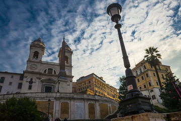 Obraz premium lamppost with trinity church and cloudy blu sky