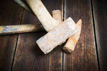 Close up of tree old used hammer on a rustic wooden background. Selective focus