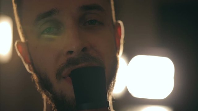 Close up shot of singer in the studio. Close up shot of microphone and man's face