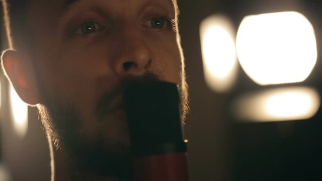 Close up shot of singer in the studio. Close up shot of microphone and man's face