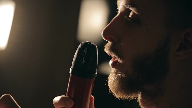 Close up shot of singer in the studio. Close up shot of microphone and man's face